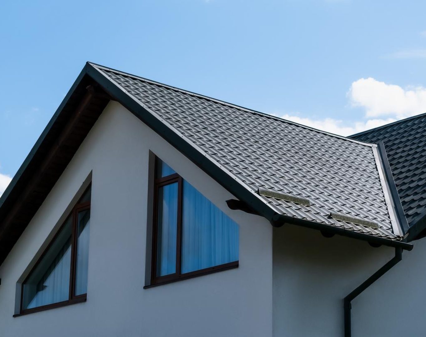 Roofing company in Adams County, CO installing shingles on a suburban home