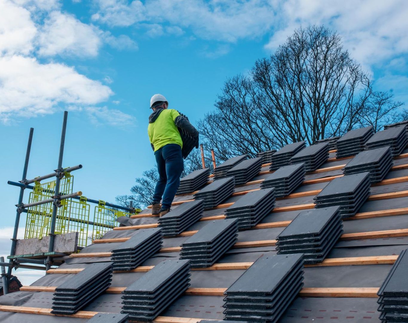 Roofing company in Lafayette, CO installing shingles on a two-story home